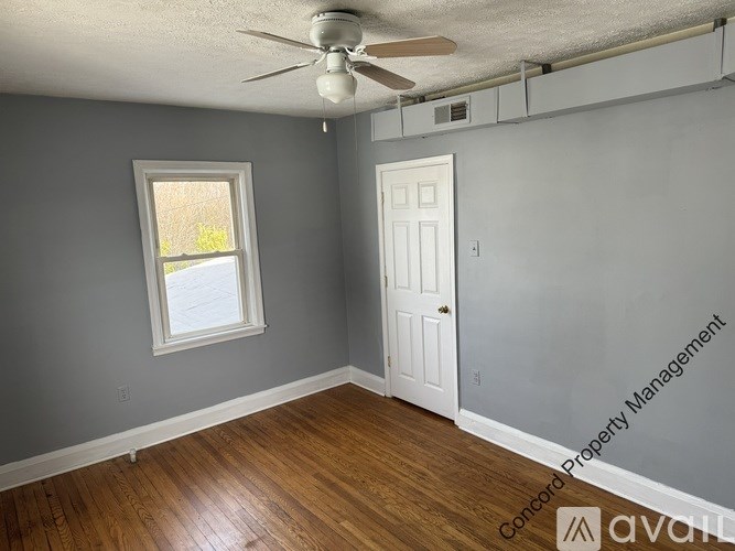 A room with a ceiling fan and a window.