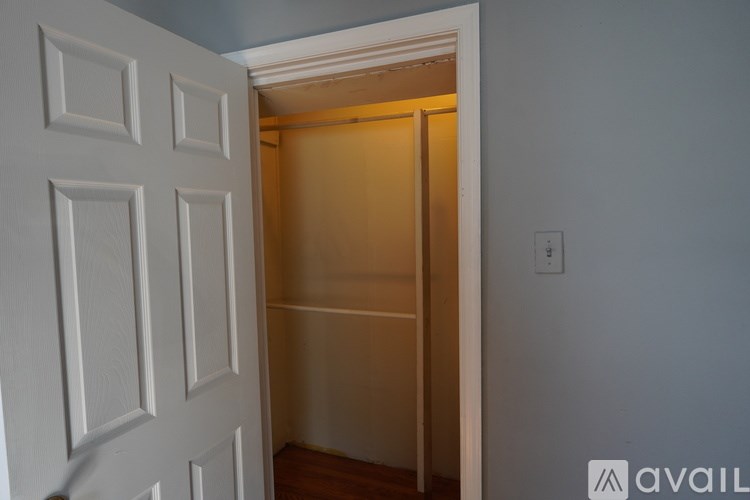 A white door with a light switch on the wall.