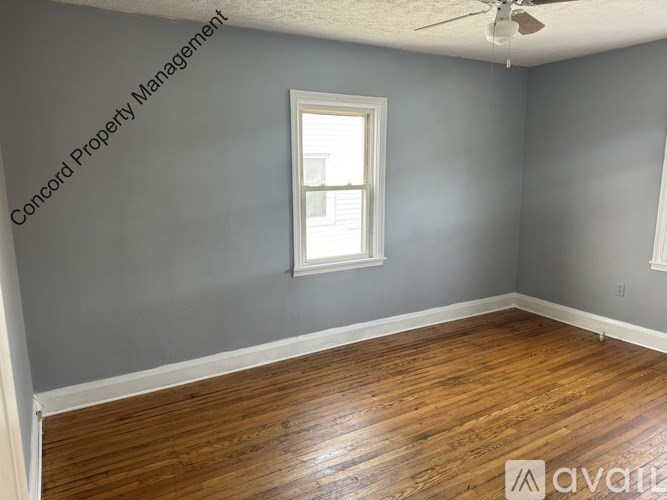 A room with a window and a ceiling fan.