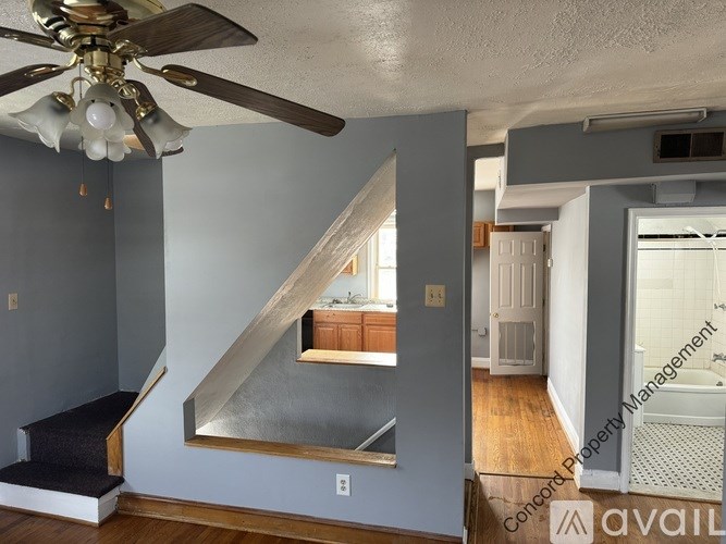 A room with a grey wall and a mirror on the wall.