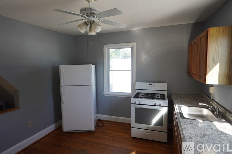 A kitchen with a white fridge, stove, and oven.