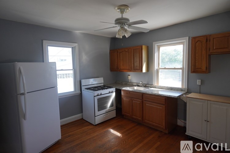 A kitchen with wooden cabinets and a white refrigerator.