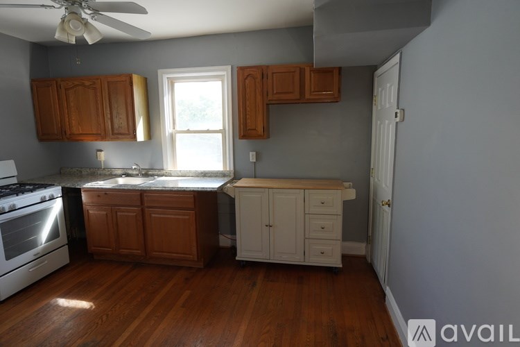 A kitchen with wooden cabinets and a white stove top oven.