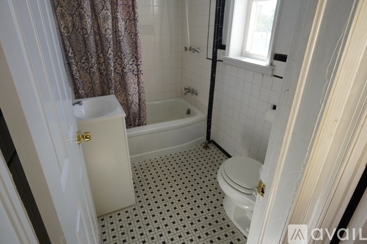 A bathroom with a toilet, sink, and bathtub.