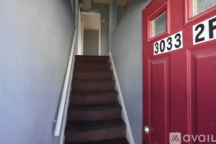 A red door with the number 3033 on it.