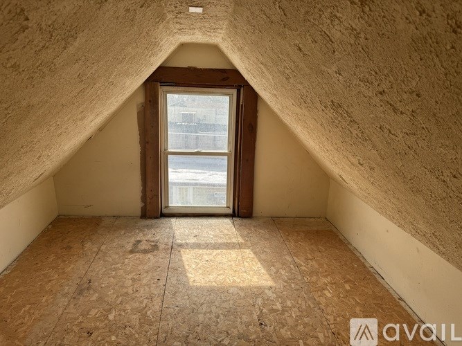 A room with a window and wooden flooring.