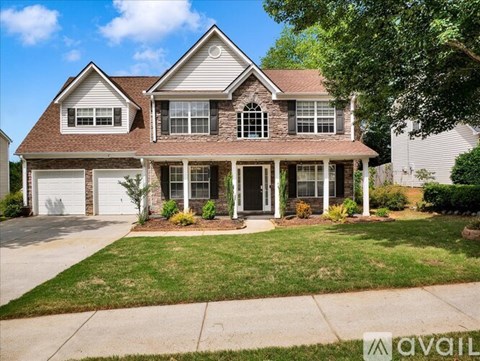 A house with a brown roof and a white garage door is for sale.