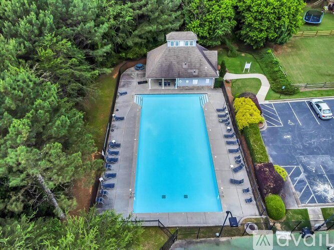 A large swimming pool surrounded by a deck and trees.