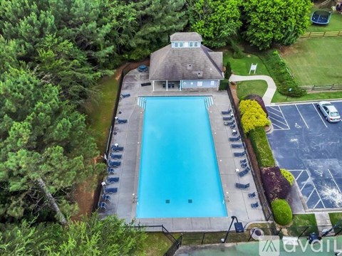 A large swimming pool surrounded by a deck and trees.