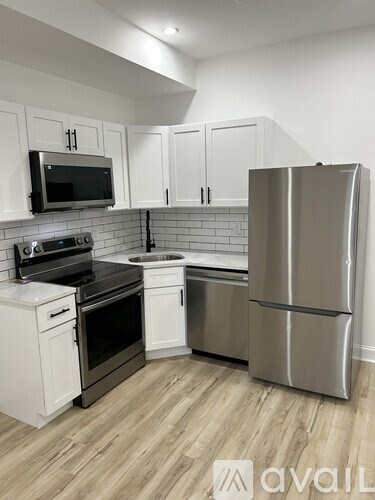 A kitchen with a stainless steel refrigerator, microwave, oven, and dishwasher.