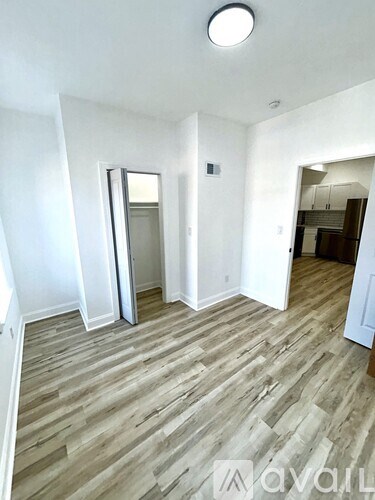 A room with wooden flooring and white walls.