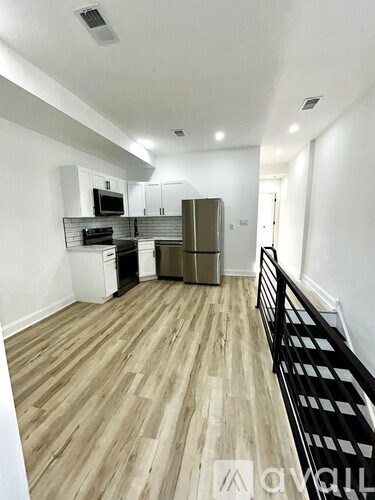 A kitchen with wooden floors and white walls.