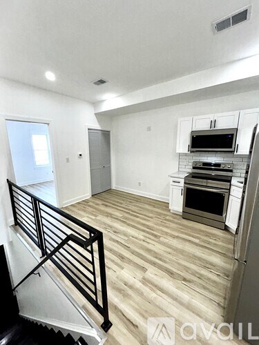 A kitchen with white cabinets and a black stove top oven.