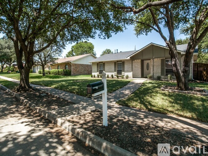 A house with a white fence and a mailbox in front.
