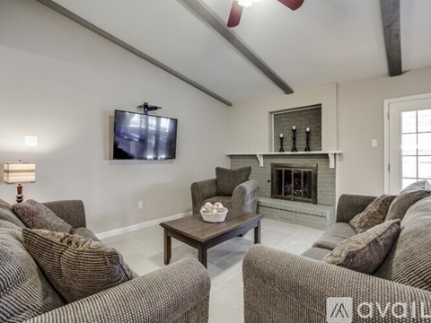 A living room with a fireplace and a television mounted on the wall.