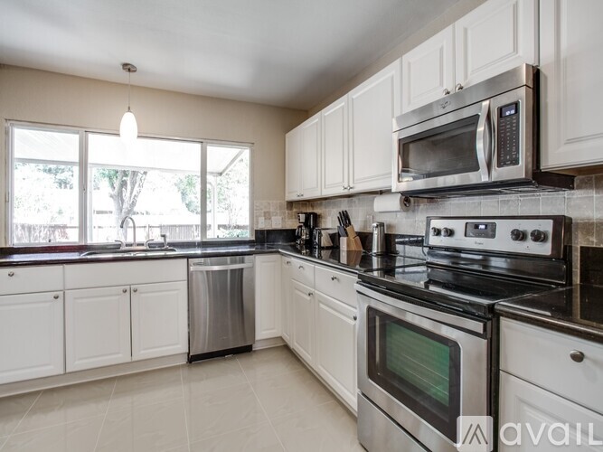 A kitchen with white cabinets and stainless steel appliances.