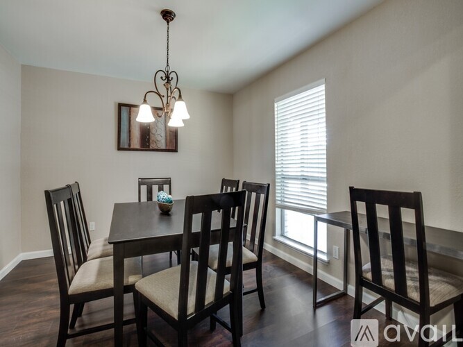 A dining room with a table and chairs.