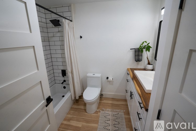 A bathroom with a toilet, sink, and shower.