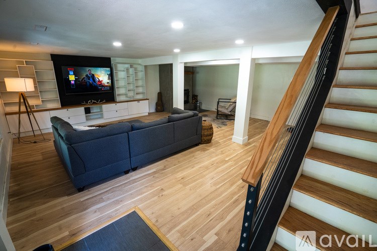 A living room with a couch and a television on the wall.
