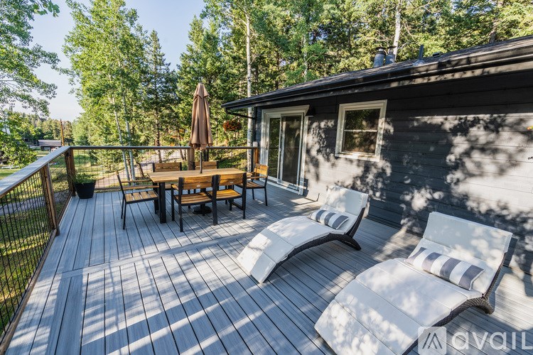 A wooden deck with two chairs and a table.