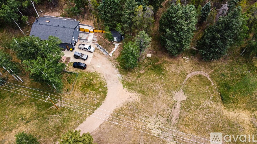 A house surrounded by trees and a dirt road.