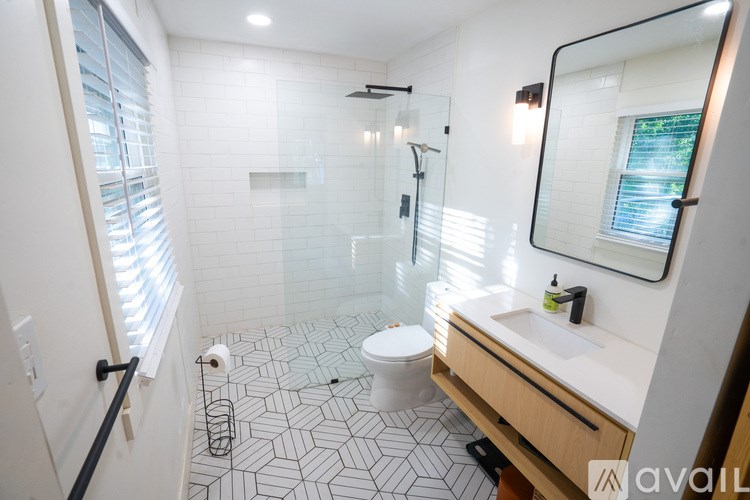 A bathroom with a toilet, sink, and shower.