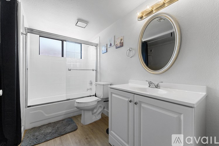 A bathroom with a white toilet, sink, and mirror.