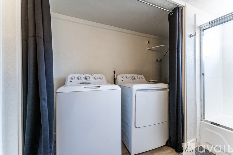 Two white washing machines in a small laundry room.