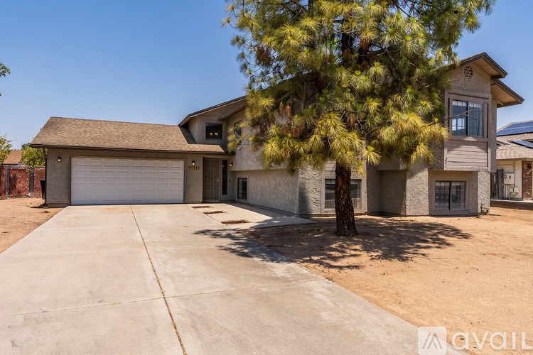 A house with a driveway and a tree in front.