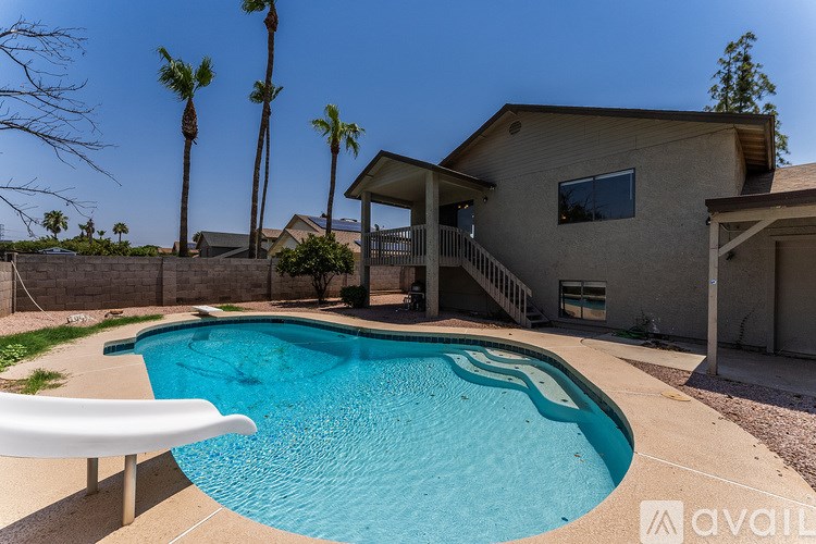 A house with a pool and palm trees in the background.