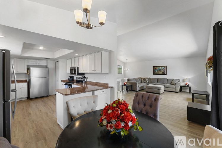 A modern kitchen with a dining table and chairs in the foreground.