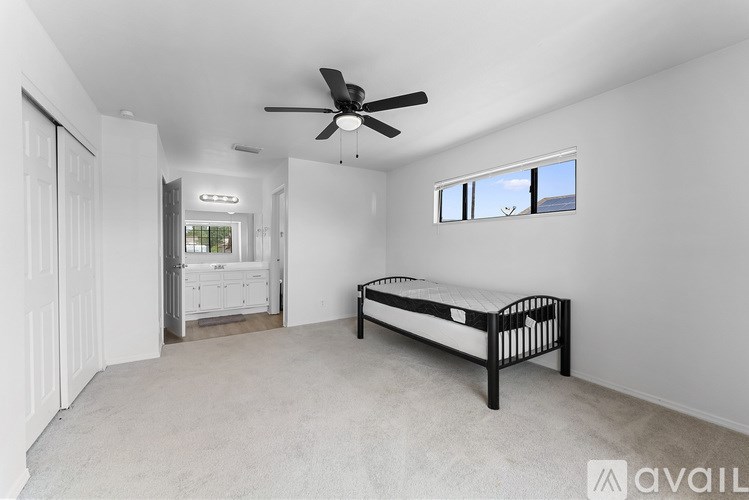 A bedroom with a bed, dresser, and window.
