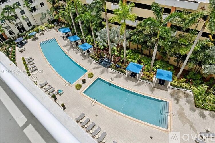 A pool surrounded by palm trees and umbrellas.