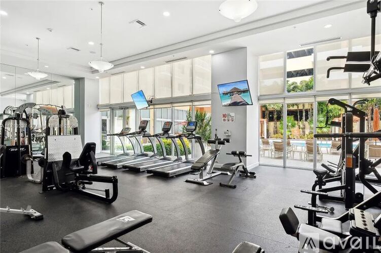 A gym with a variety of equipment including treadmills, weights, and exercise machines.