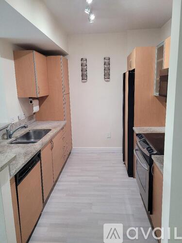 A kitchen with wooden cabinets and a black refrigerator.