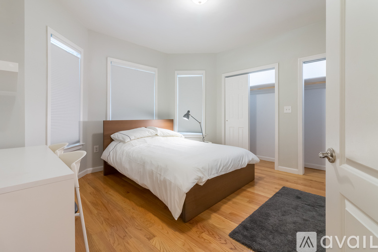 A bedroom with a bed, a tripod, and a white door.