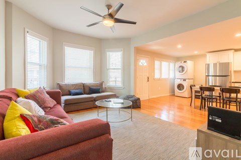 A living room with a red couch and a ceiling fan.