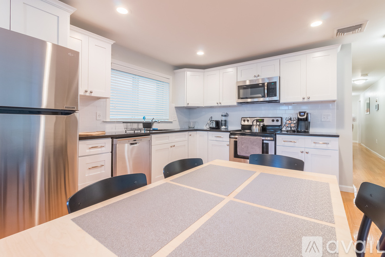 A kitchen with a table and chairs in the middle.