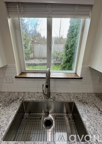 A kitchen sink with a window above it.