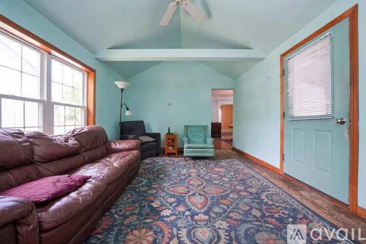 A living room with a red couch and a rug.
