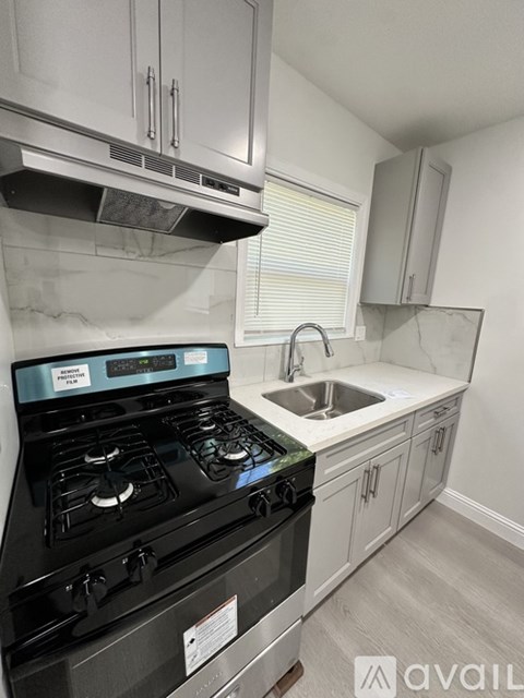 A modern kitchen with a black stove top oven and white cabinets.