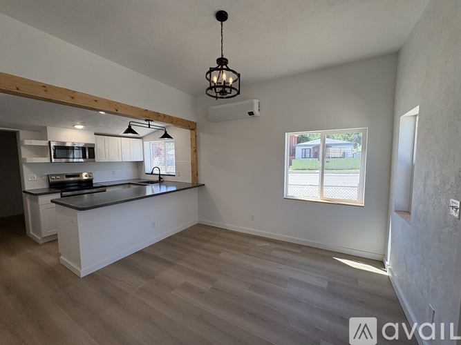 A kitchen with a black countertop and white cabinets is available for rent.