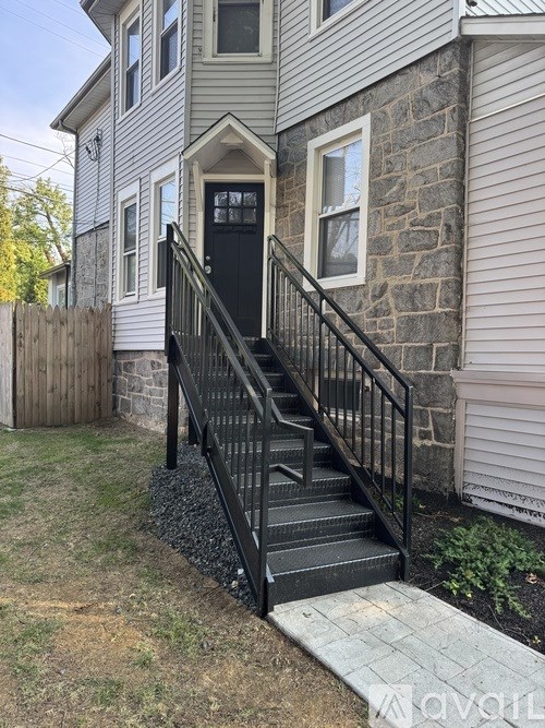 A house with a grey siding and a black door.