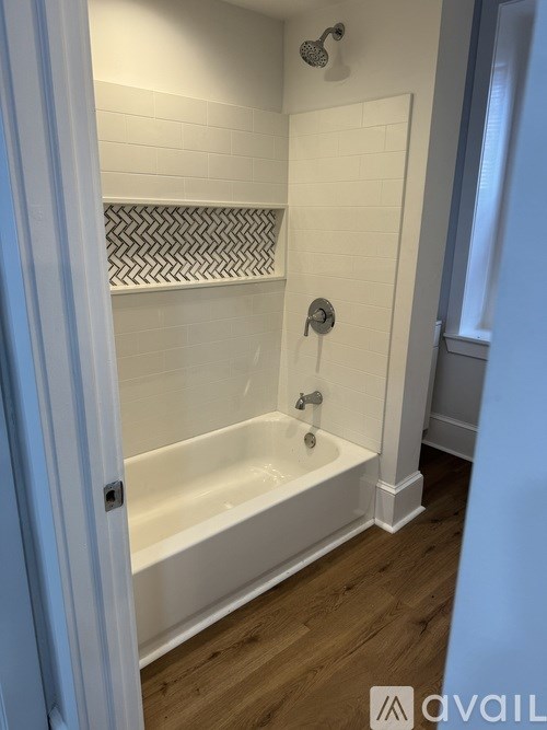 A white bathroom with a white tub and a white shower.