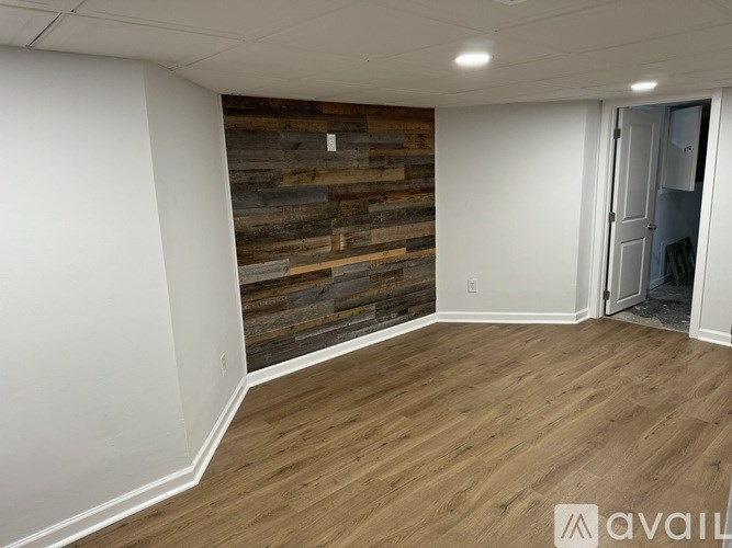 A room with wooden flooring and a wooden wall panel.