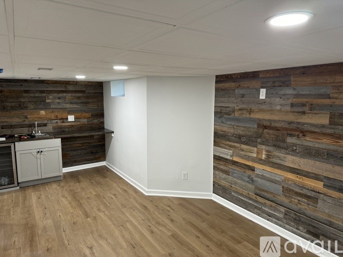 A room with a wooden wall and a white wall.