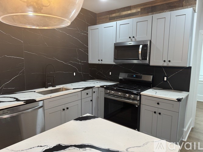 A kitchen with a black stove top oven and a black microwave above it.