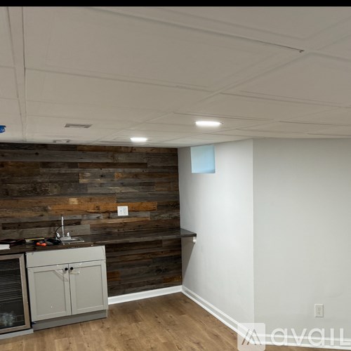 A kitchen with a wooden wall and a grey cabinet.