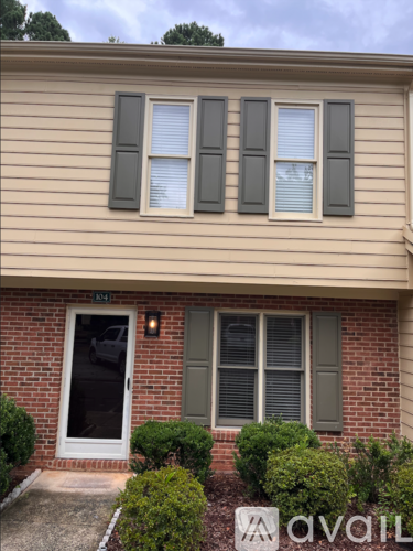 A house with a white door and two windows with shutters.