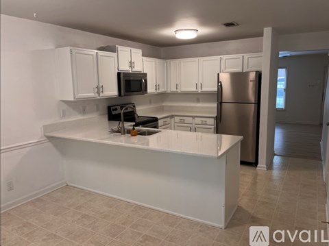 A kitchen with white cabinets and appliances.